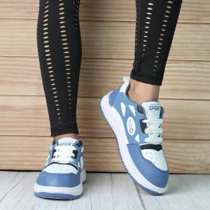 Trendy blue and white sneakers with black leggings, indoors on a wooden floor.